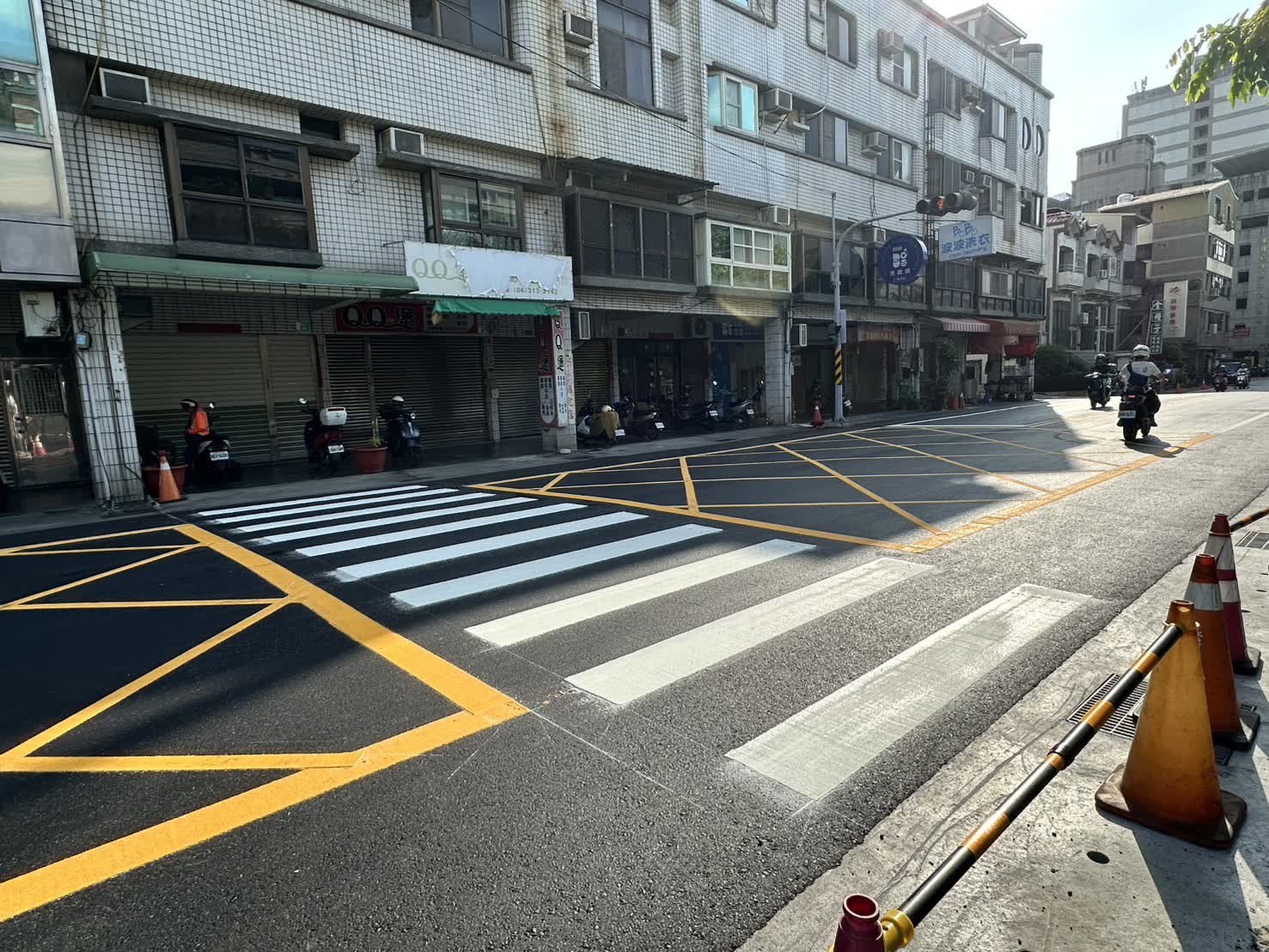 華興街新鋪柏油路面的斑馬線、黃色網狀禁停線與路緣側溝蓋板